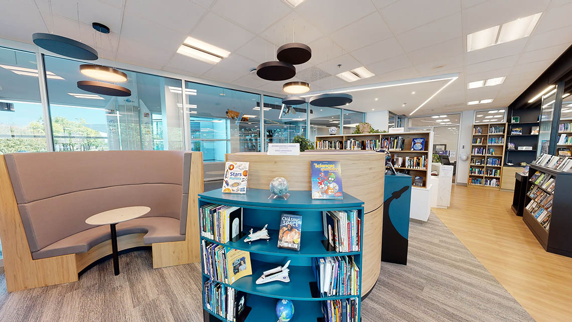 Espace ouvert et aéré avec des étagères et des bancs arrondis.