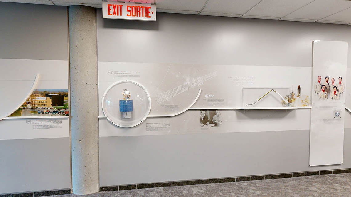 A wall timeline featuring a picture of the David Florida Laboratory, small models of the Anik A1 satellite and of Canadarm, as well as a panel with a photo of the first Canadian astronaut corps.