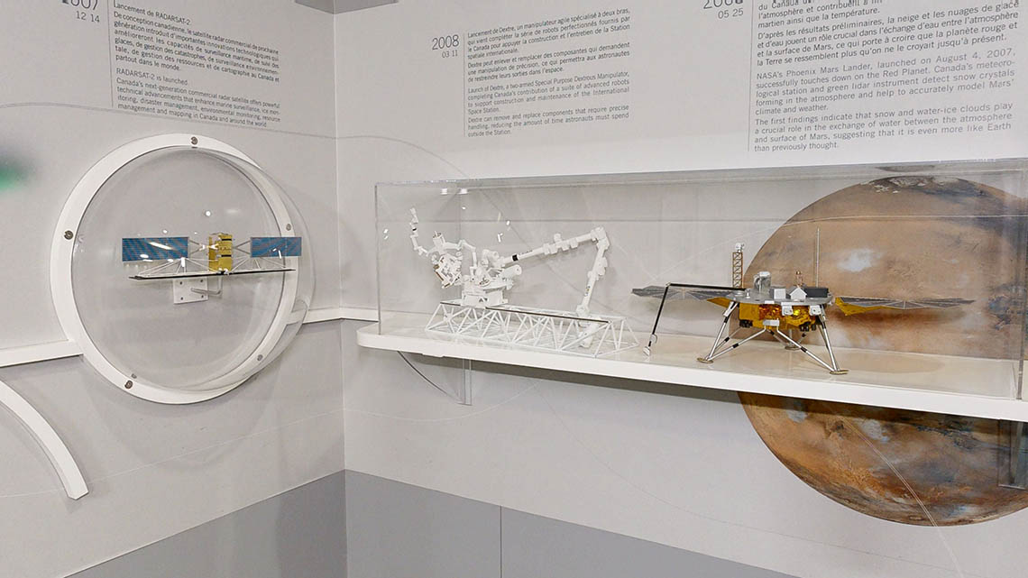 Small models of the RADARSAT-2 satellite, Canadarm2 and Dextre, and the Phoenix Mars Lander.