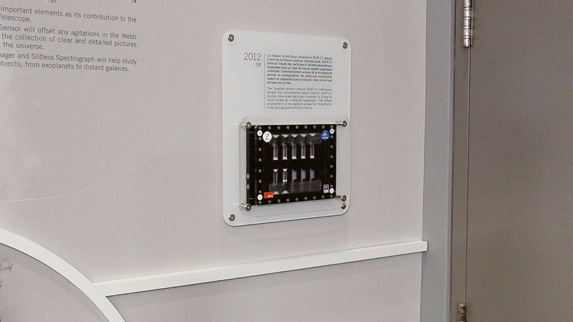 A clear acrylic case is mounted on the wall, with space to house ten experiment samples.