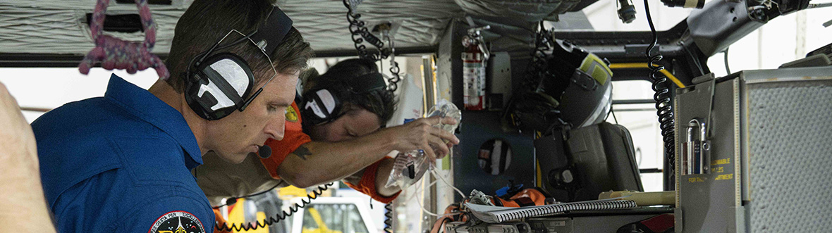 Joshua is with two people in a helicopter looking at medical supplies.