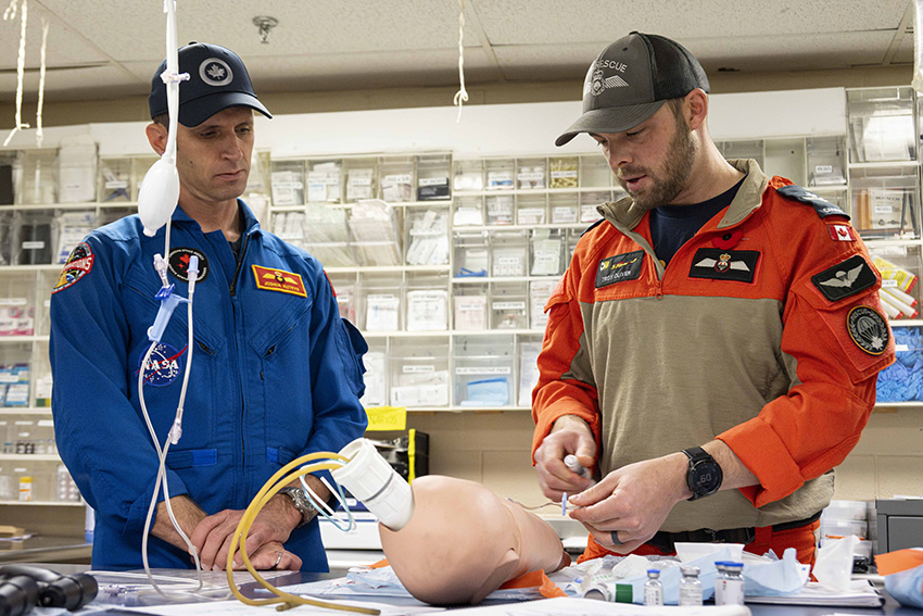 Joshua and a technician use a mannequin head for a medical simulation.