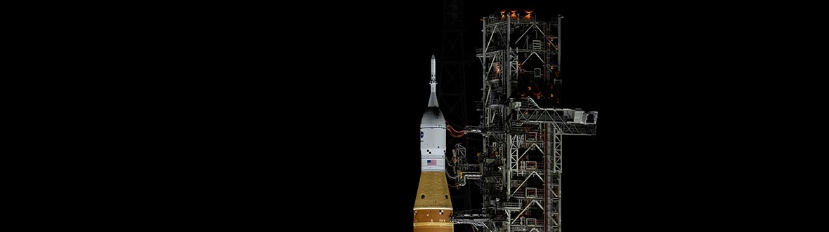 A rocket on a launch pad at night.