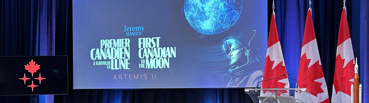 A stage with a large screen, a smaller screen, two stools, and three Canadian flags.