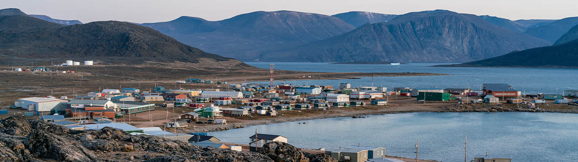 Dusk in a harsh arctic landscape with bare hills and ocean