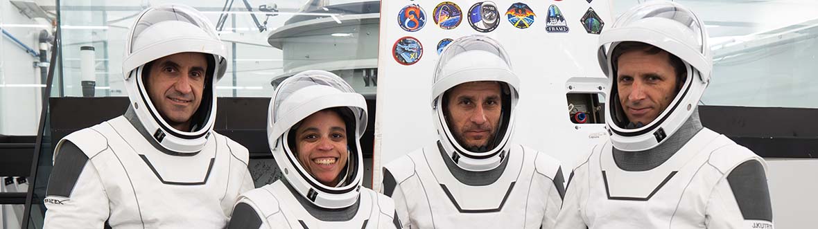 Crew-13: Sergey, Jessica, Luke, and Joshua stand beside each other wearing space suits.