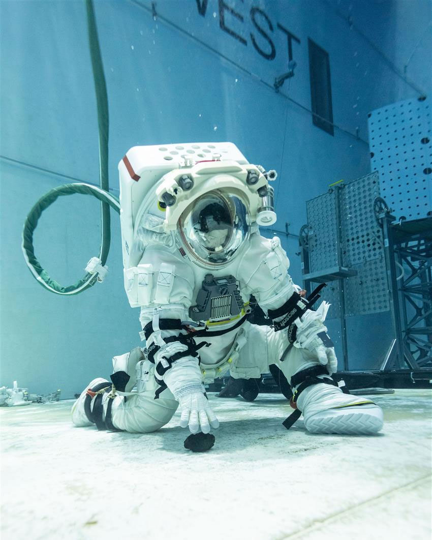 Jenni s'exerce à des tâches lunaires sous l'eau dans une combinaison spatiale.