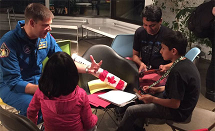 CSA astronaut Jeremy Hansen chats with Arushi, Artash and their father Vikas Nath after the opening session of the Space Apps Toronto.