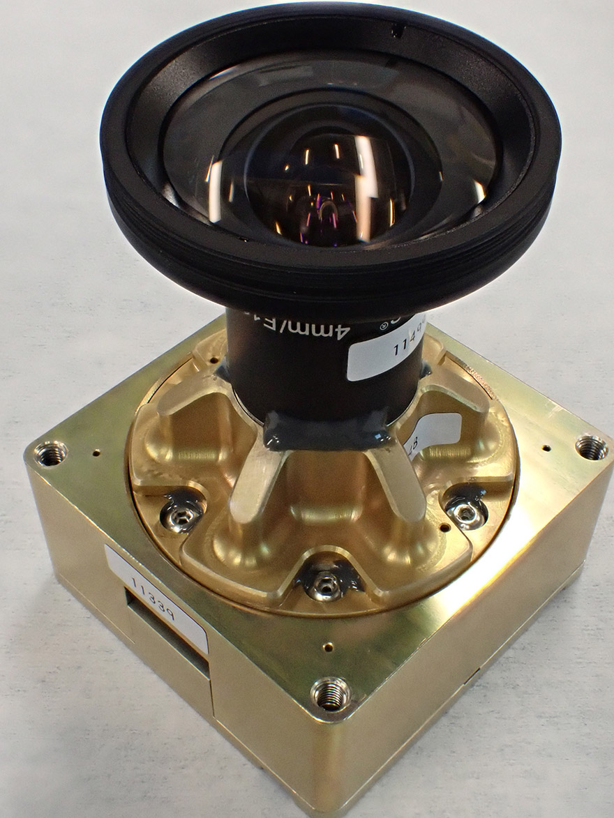 Gros plan d'une caméra dont l'objectif est monté sur un boîtier métallique de couleur dorée.