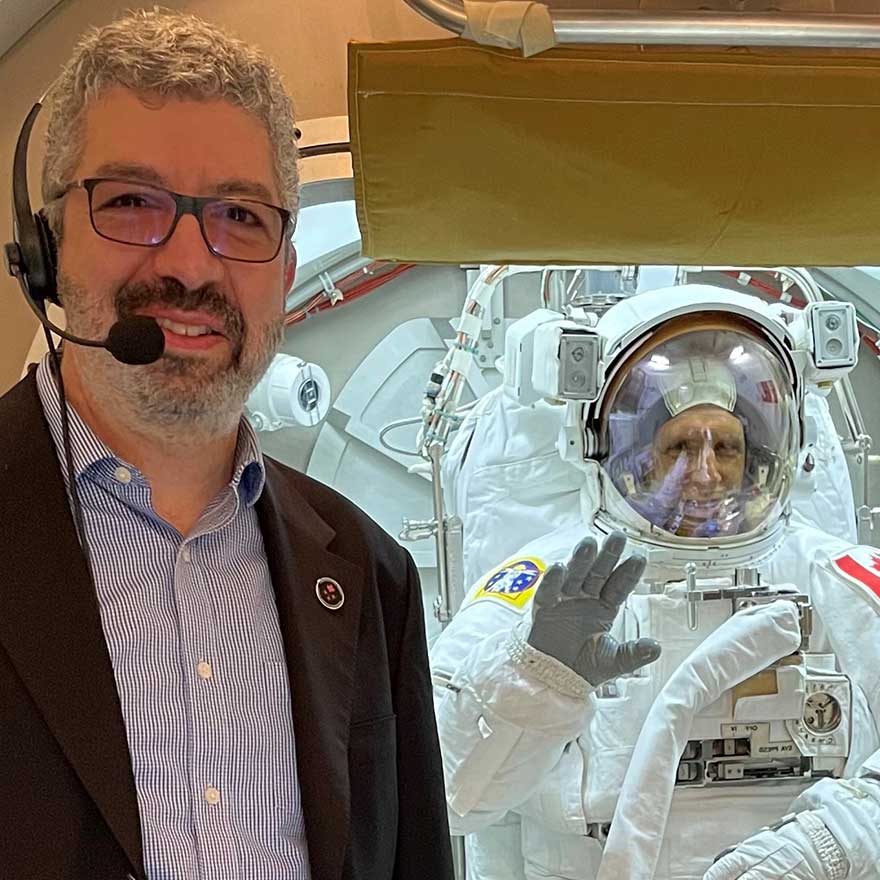 Raffi Kuyumjian pose devant Joshua Kutryk, qui porte une combinaison spatiale.