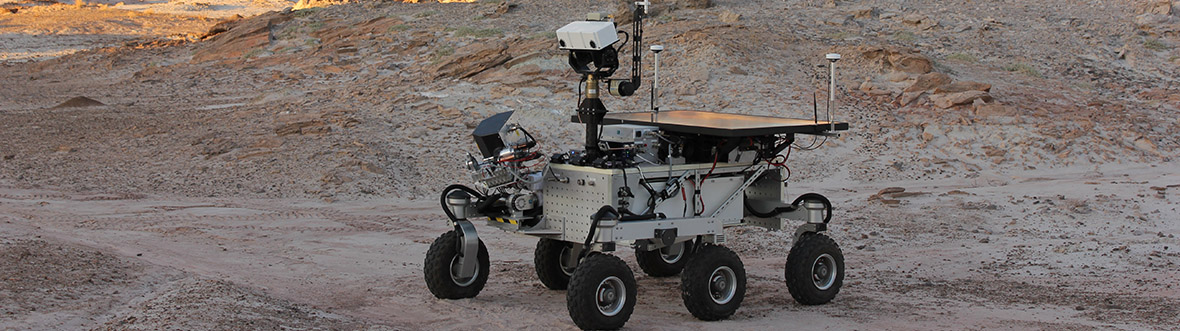 A rover is in the Utah desert. It has six wheels and is equipped with sensors and science instruments.
