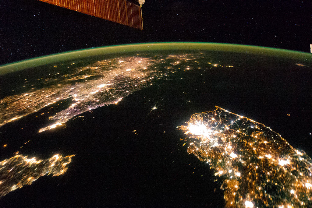 North Korea appears almost fully blacked out between China (top left) and South Korea (bottom right) in this night image of the Korean Peninsula taken by an astronaut aboard the International Space Station. The capital city, Pyongyang, is the dot of light visible in the center. The countries' borders are so dark they are almost indistinguishable from the Yellow Sea and Sea of Japan on either side. (Credit: NASA)