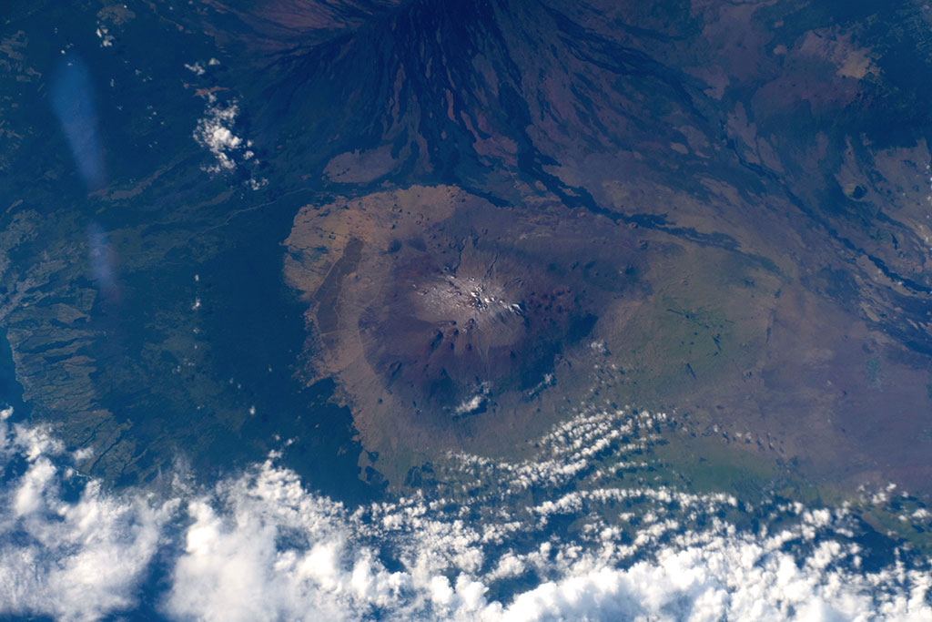 Mauna Kea, captured by David Saint-Jacques from the International Space Station, is one of five volcanoes that form the islands of Hawaii. It is a dormant volcano and its peak is 4,207.3 m above sea level, making it the highest point in the state of Hawaii. Most of the mountain is under water, and when measured from its oceanic base, Mauna Kea is the tallest mountain in the world measuring over 10,000 m. (Credit: Canadian Space Agency/NASA)
