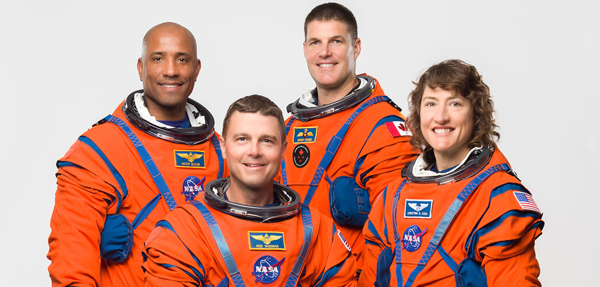 Le commandant d'Artemis II Reid Wiseman, assis sur un tabouret, est entouré des trois autres membres d'équipage