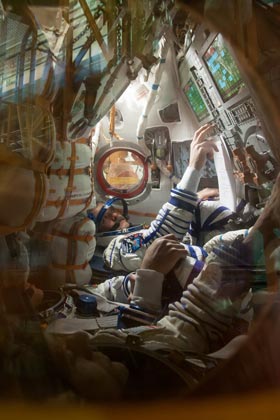 Hadfield and crew mates perform a fit-check in the Soyuz module