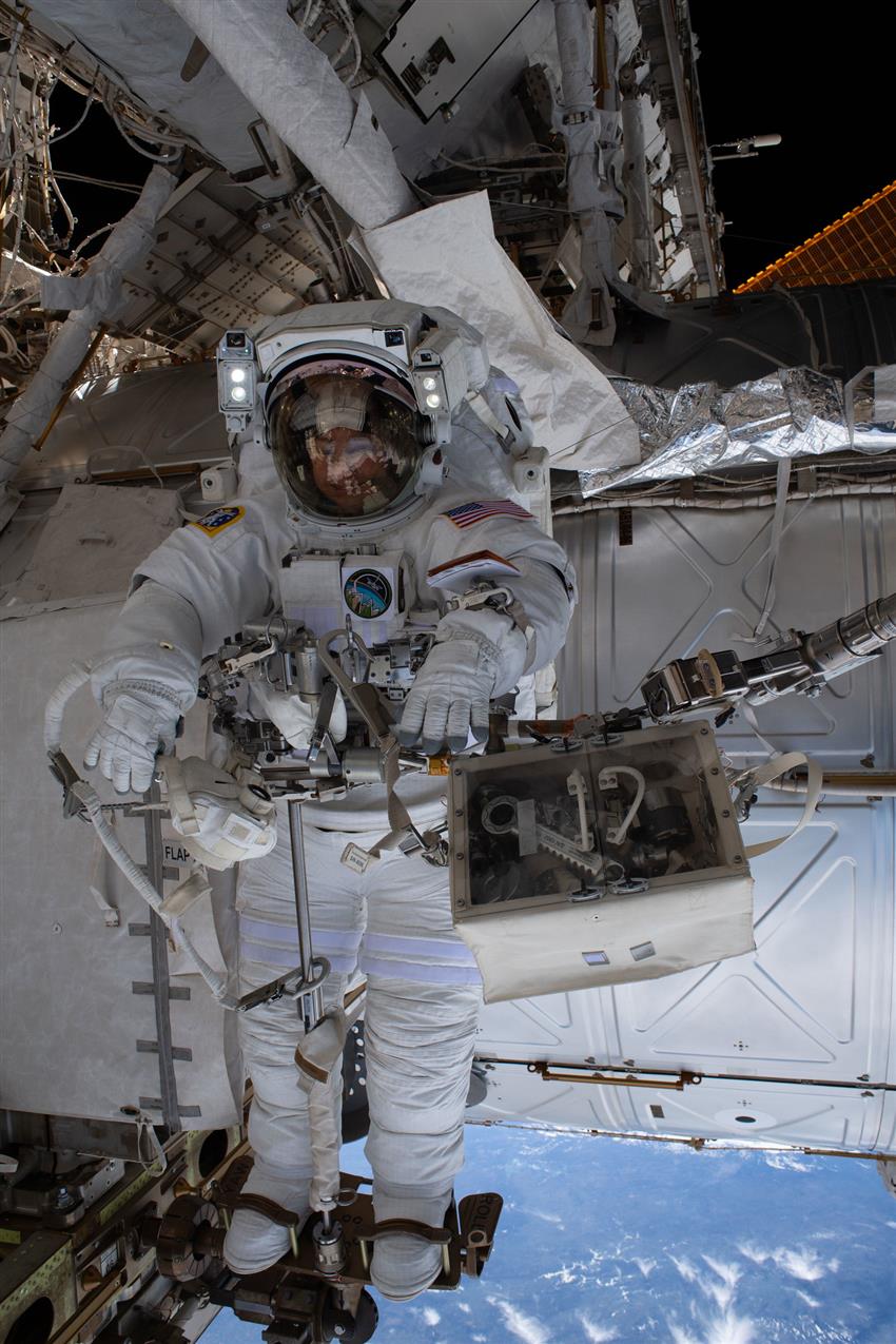 Jessica, en combinaison spatiale, est maintenue en place par un cale-pieds à l'extérieur de la Station.