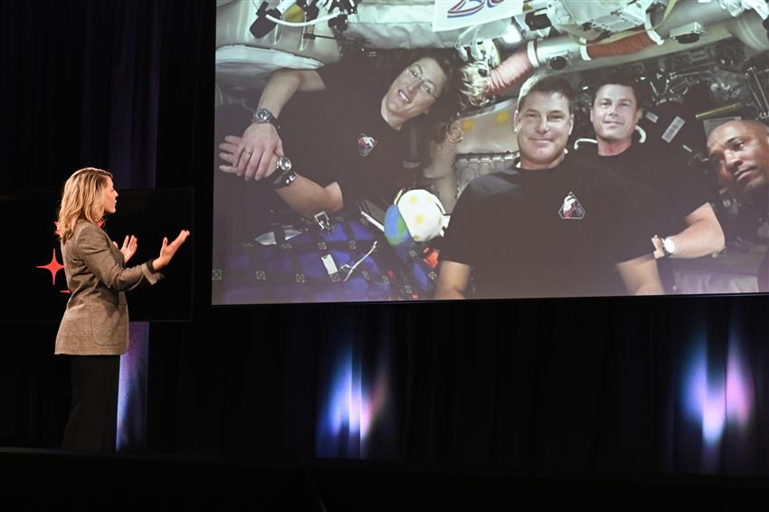 Mélanie Joly speaks to the Artemis II crew, who can be seen on a big screen.