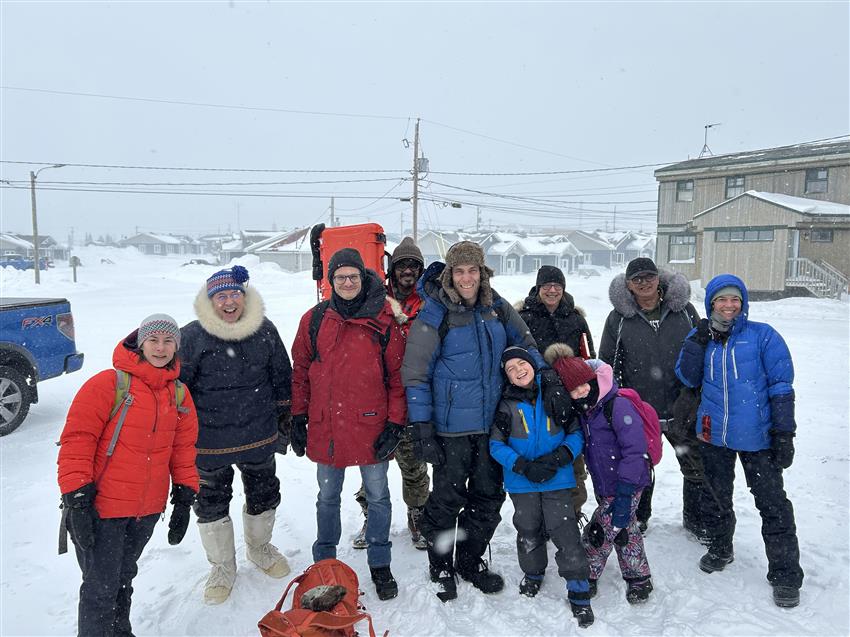 Photo de groupe d'une dizaine de personnes dehors en hiver, vêtues chaudement.