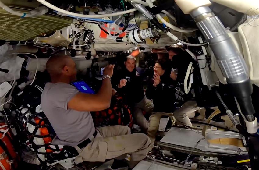 Dans le vaisseau spatial Orion, Victor, Christina et Reid applaudissent Jeremy qui tient son insigne en or.