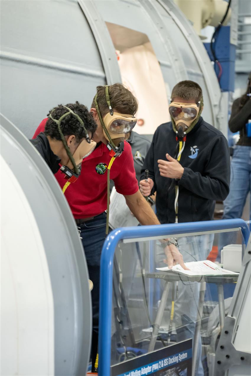 Jessica, Joshua, and Andrey wear protective breathing masks.